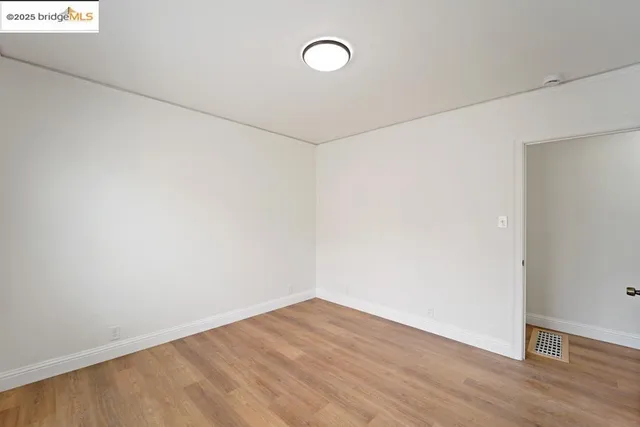 a view of a kitchen with white cabinets and wooden floor