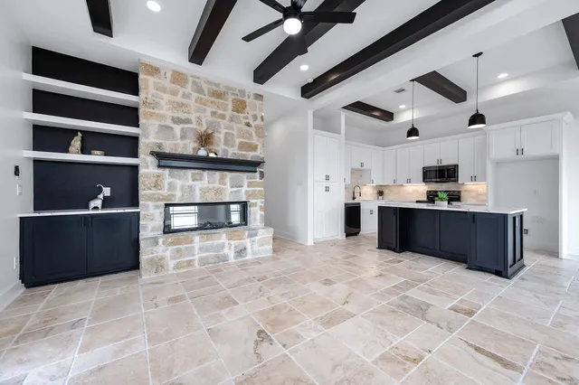 a large kitchen with stainless steel appliances granite countertop a refrigerator and a stove