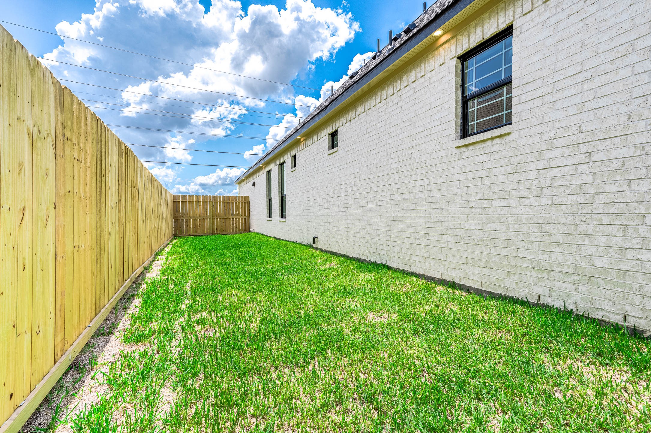 8903 Milby Street Needville, TX 77461 - Photo 32 of 32 a view of a backyard with potted plants and wooden fence