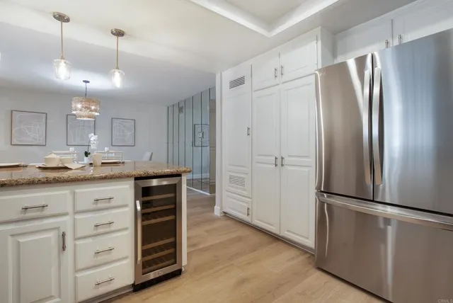 a kitchen with granite countertop a refrigerator and cabinets