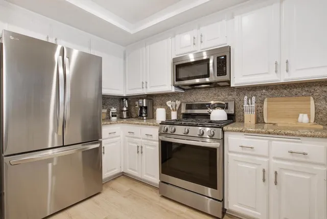 a kitchen with cabinets stainless steel appliances and a counter space