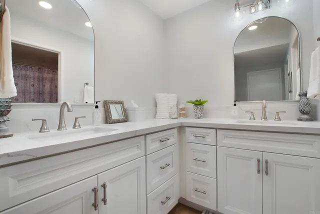 a bathroom with double sink and a mirror