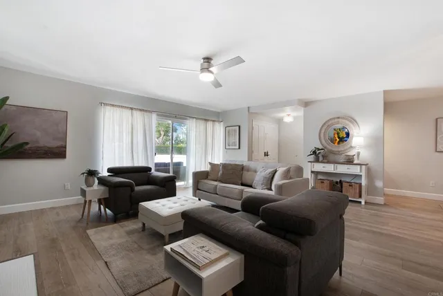 a living room with furniture and a wooden floor