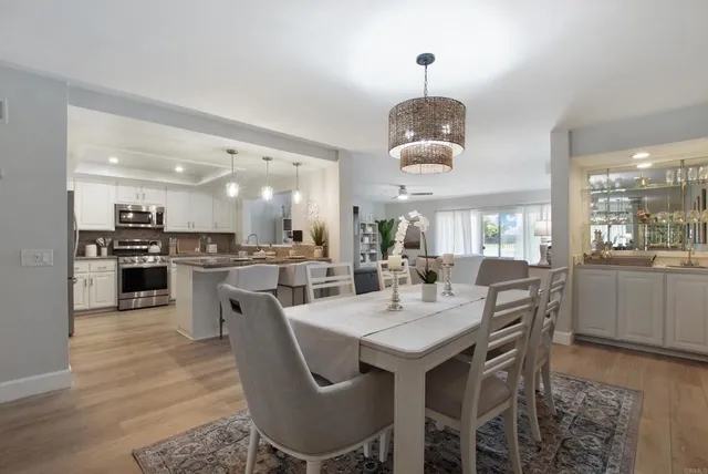 a dining room with stainless steel appliances kitchen island granite countertop a dining table chairs and a oven