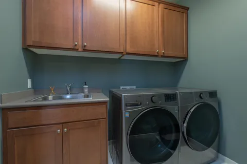 a utility room with sink dryer and washer