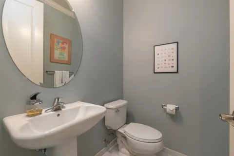 a bathroom with a toilet sink and mirror