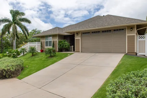 a front view of a house with a garden and plants