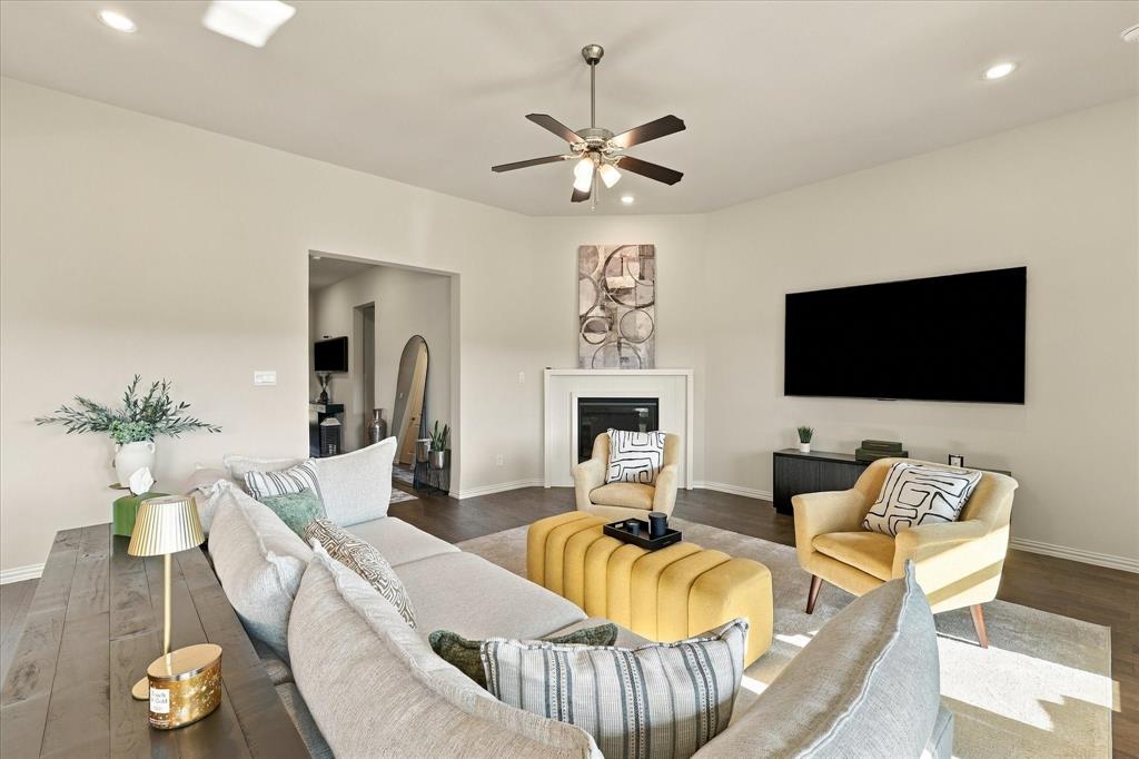 137 Chisos Court Rhome, TX 76078 - Photo 7 of 40 Recessed lighting, ceiling fan, wood-finish flooring, white fireplace surround, and a wall-mounted entertainment console