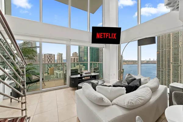 a living room with furniture and a floor to ceiling window