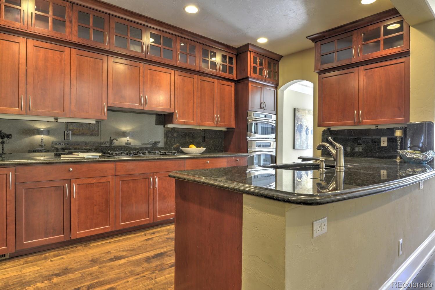 490 Columbine Street Denver, CO 80206 - Photo 19 of 33 a kitchen with stainless steel appliances granite countertop a sink and cabinets