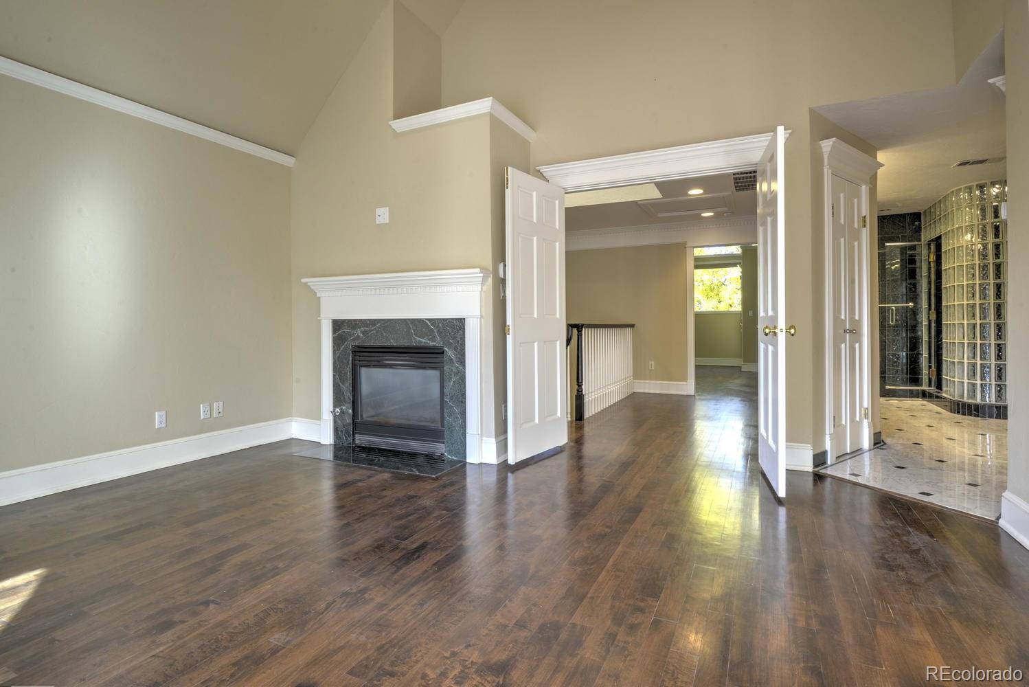 490 Columbine Street Denver, CO 80206 - Photo 22 of 33 a view of a hallway with wooden floor a fireplace and a window