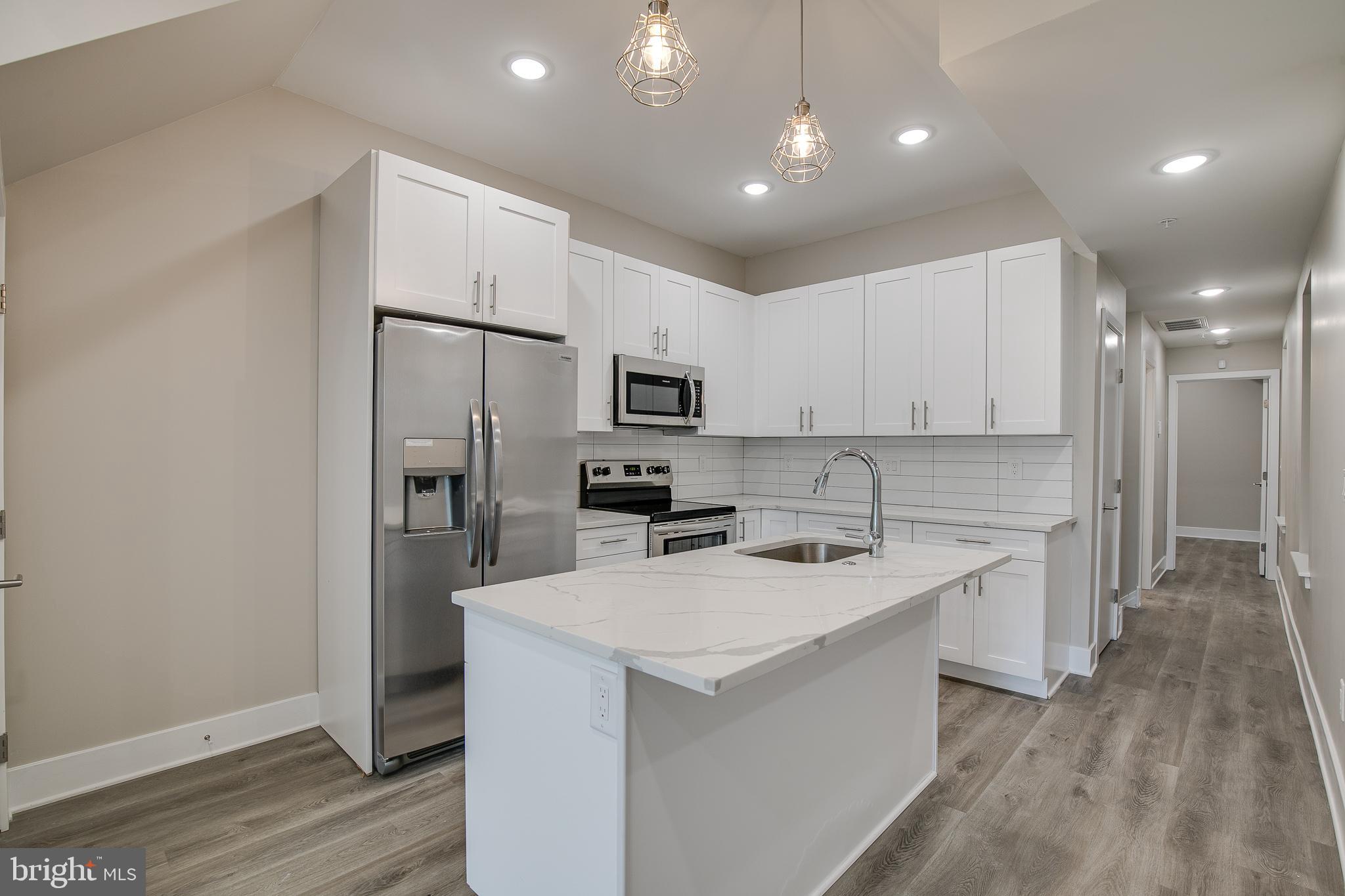 2017 North College Avenue, Unit 1 Philadelphia, PA 19121 - Photo 22 of 27 a kitchen with a sink stainless steel appliances and white cabinets
