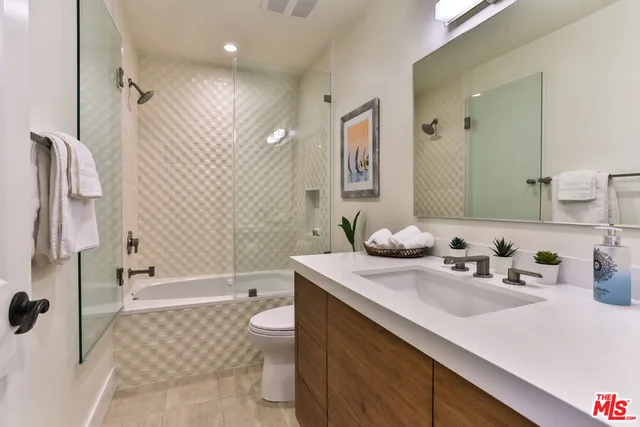 a bathroom with a double vanity sink mirror and shower