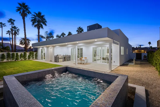 a view of a house with a swimming pool and sitting area