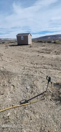 a view of a dry yard with mountain in the background