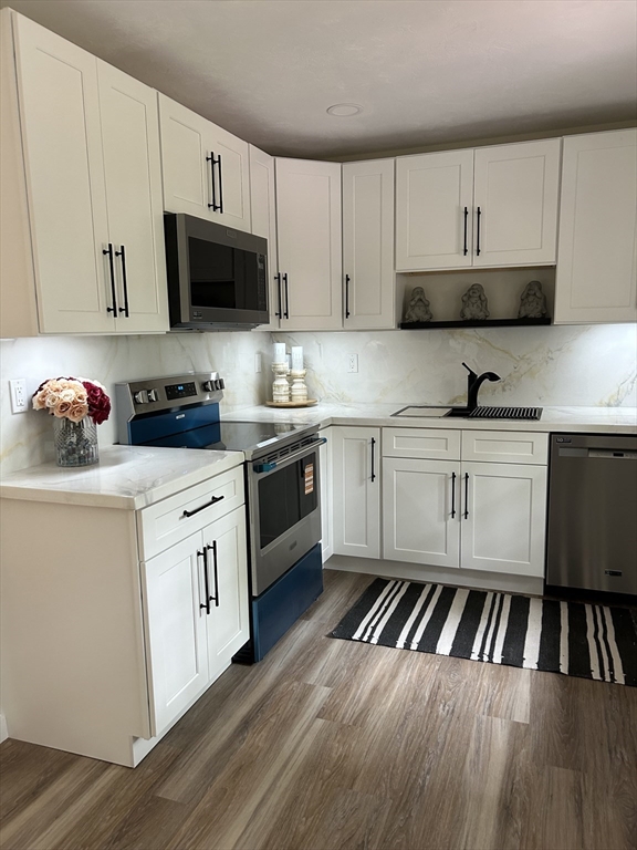 61 Esta Road Plymouth, MA 02360 - Photo 13 of 40 a kitchen with stainless steel appliances a sink dishwasher a stove and microwave with wooden floor