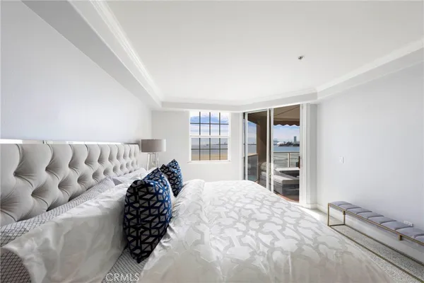 a bed sitting in a bedroom next to a window and dresser