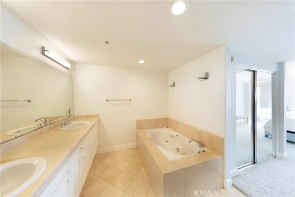 a spacious bathroom with a tub sink and mirror