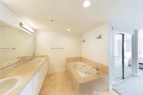 a spacious bathroom with a tub sink and mirror