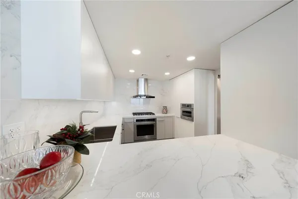 a kitchen with stainless steel appliances kitchen island granite countertop a refrigerator and a sink