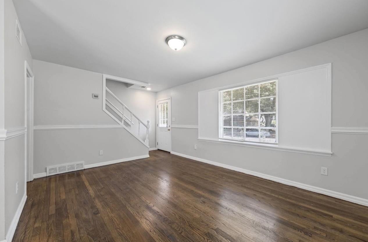 3843 Blue Jay Road Memphis, TN 38116 - Photo 7 of 23 an empty room with wooden floor and windows