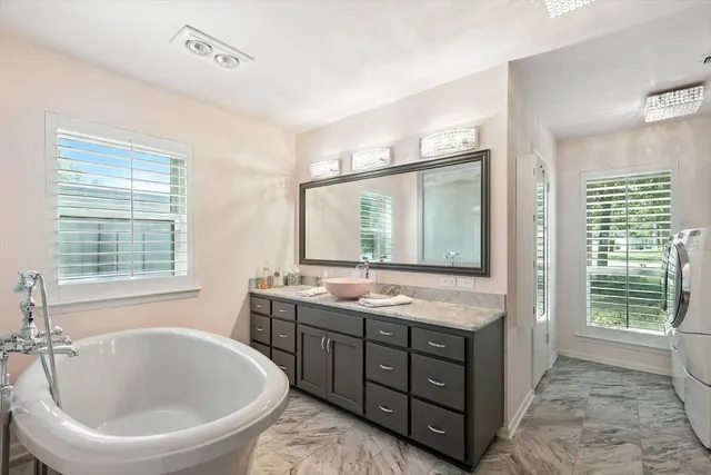 a bathroom with a tub sink and mirror