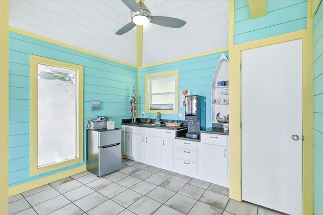 a kitchen with white cabinets and sink