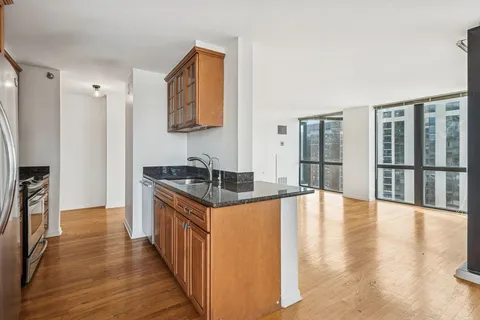 a kitchen with granite countertop a stove and a wooden floors