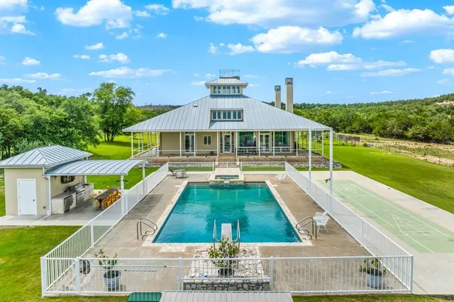 a front view of house with swimming pool and yard