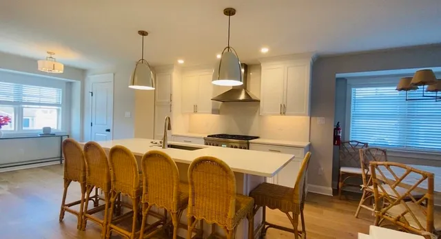 a kitchen with stainless steel appliances granite countertop a stove a refrigerator a kitchen island a sink and a refrigerator