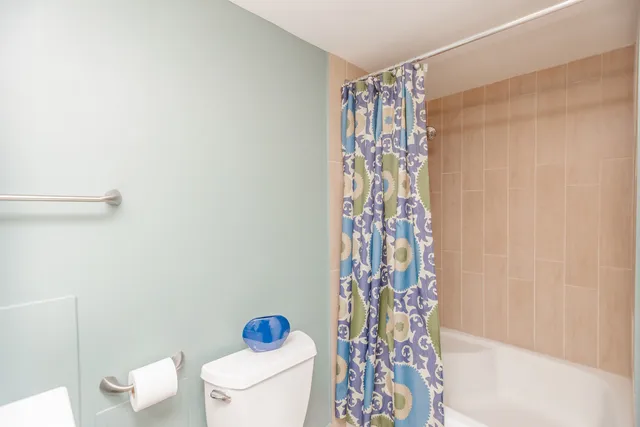 a bathroom with a toilet and a shower curtain