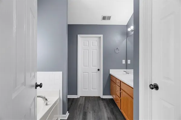 a bathroom with a tub sink and mirror