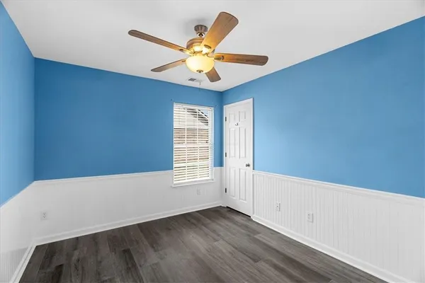 a view of an empty room with window and wooden floor