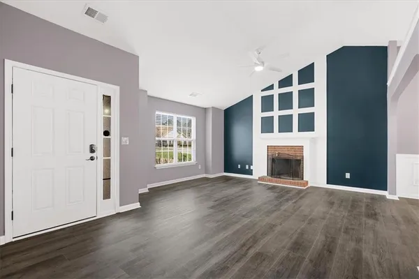 a view of an empty room with a window and fireplace