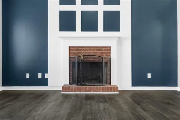 a view of a livingroom with wooden floor and a fireplace