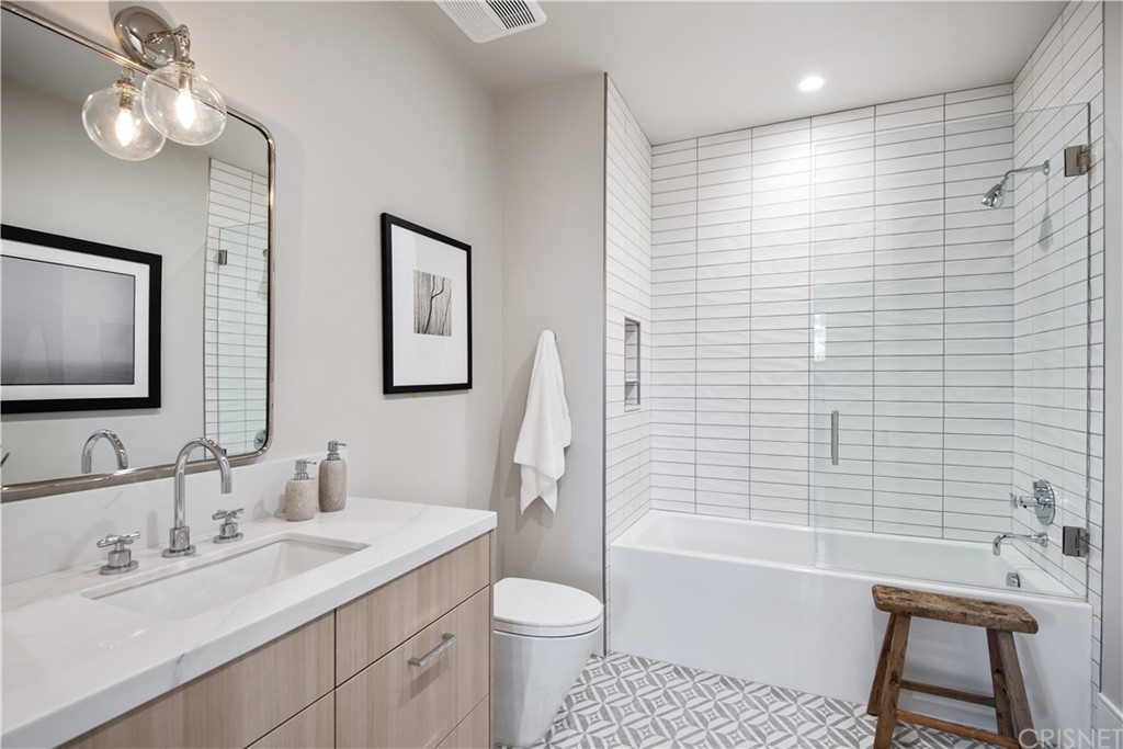 5757 Hoback Glen Road Hidden Hills, CA 91302 - Photo 31 of 47 a bathroom with a toilet a sink a tub and mirror