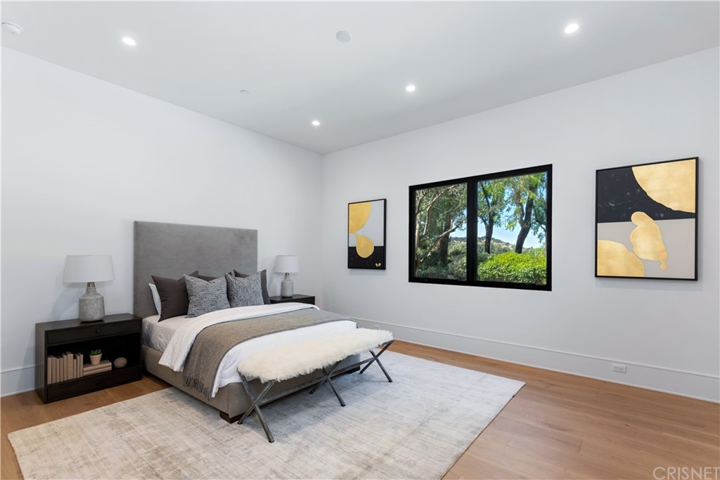 5757 Hoback Glen Road Hidden Hills, CA 91302 - Photo 32 of 47 a bedroom with a bed and a painting on the wall