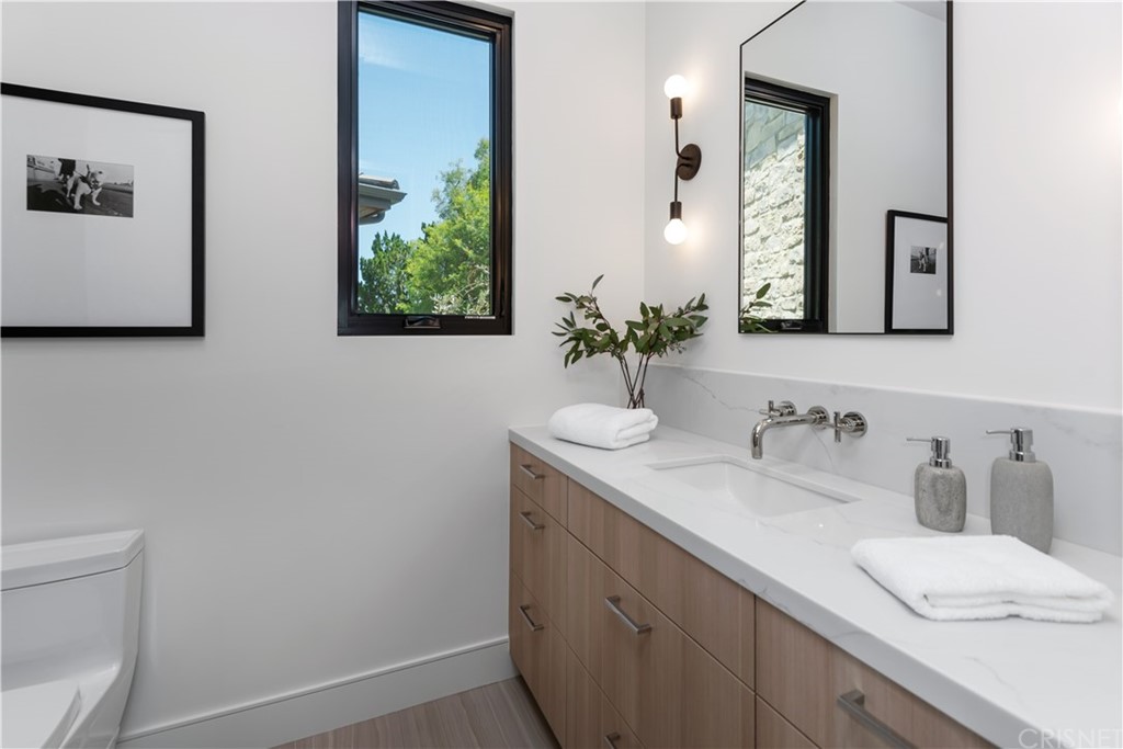 5757 Hoback Glen Road Hidden Hills, CA 91302 - Photo 33 of 47 a bathroom with a granite countertop sink and a mirror