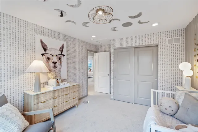 a spacious bedroom with a bed and a lamp