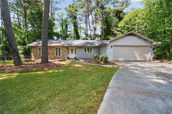 a front view of a house with a yard and trees