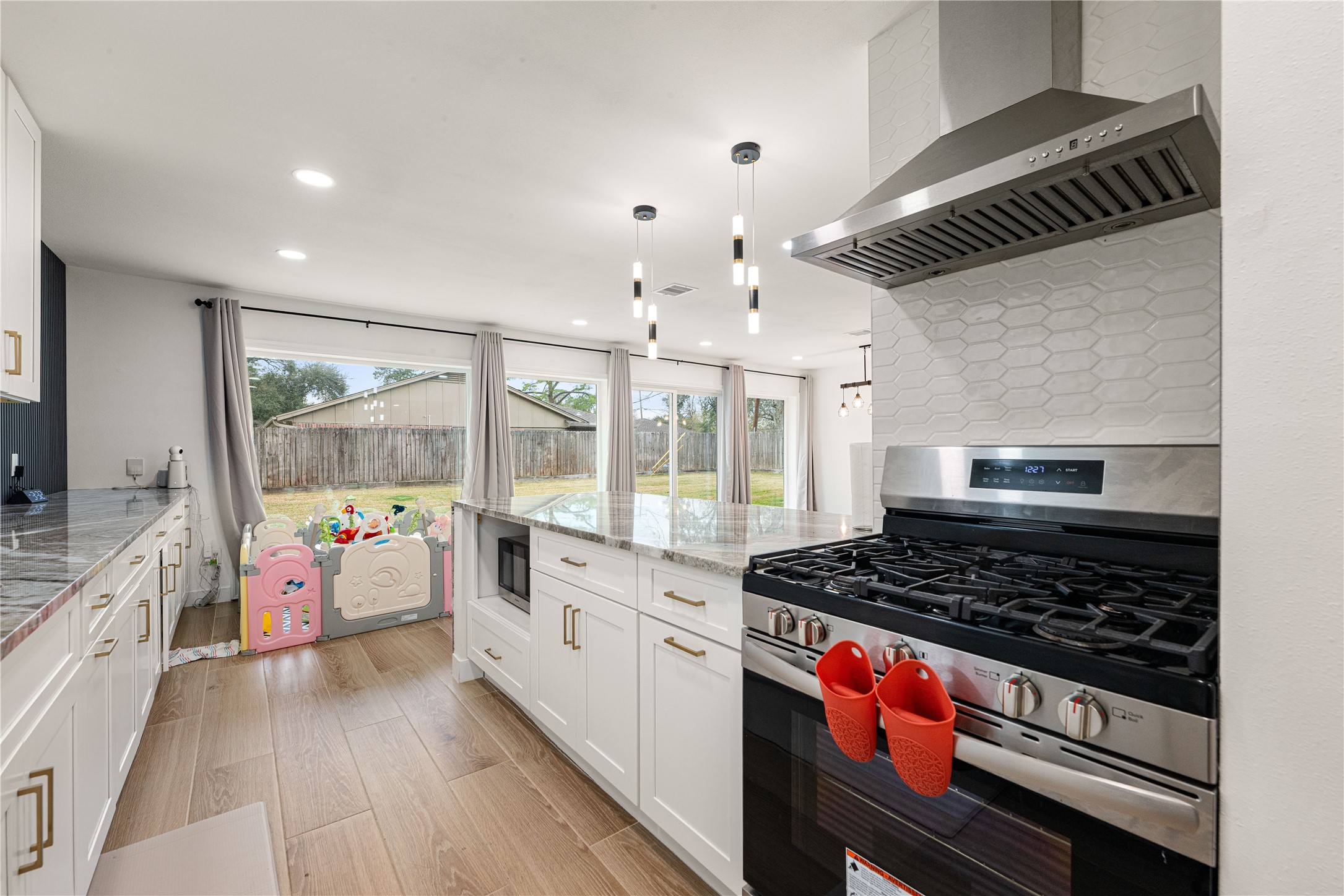 3410 Tanglewilde Street Houston, TX 77063 - Photo 9 of 17 a kitchen with stove and wooden floor