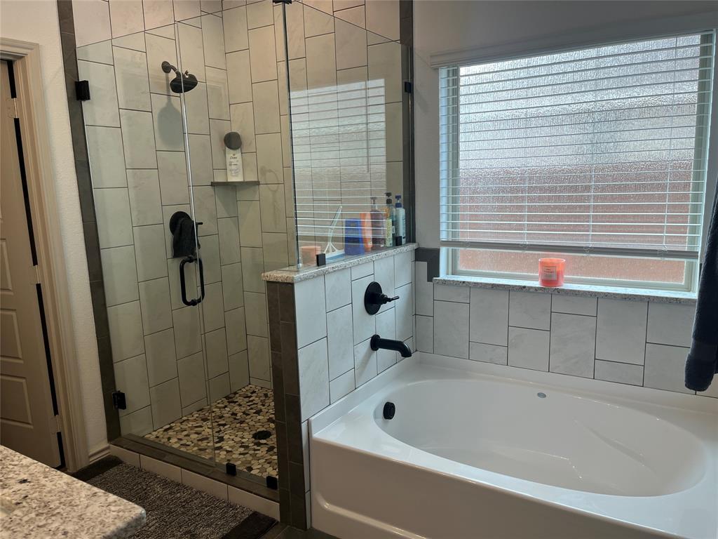 108 Wiley Stephenville, TX 76401 - Photo 16 of 25 a bathroom with a tub a window and a shower