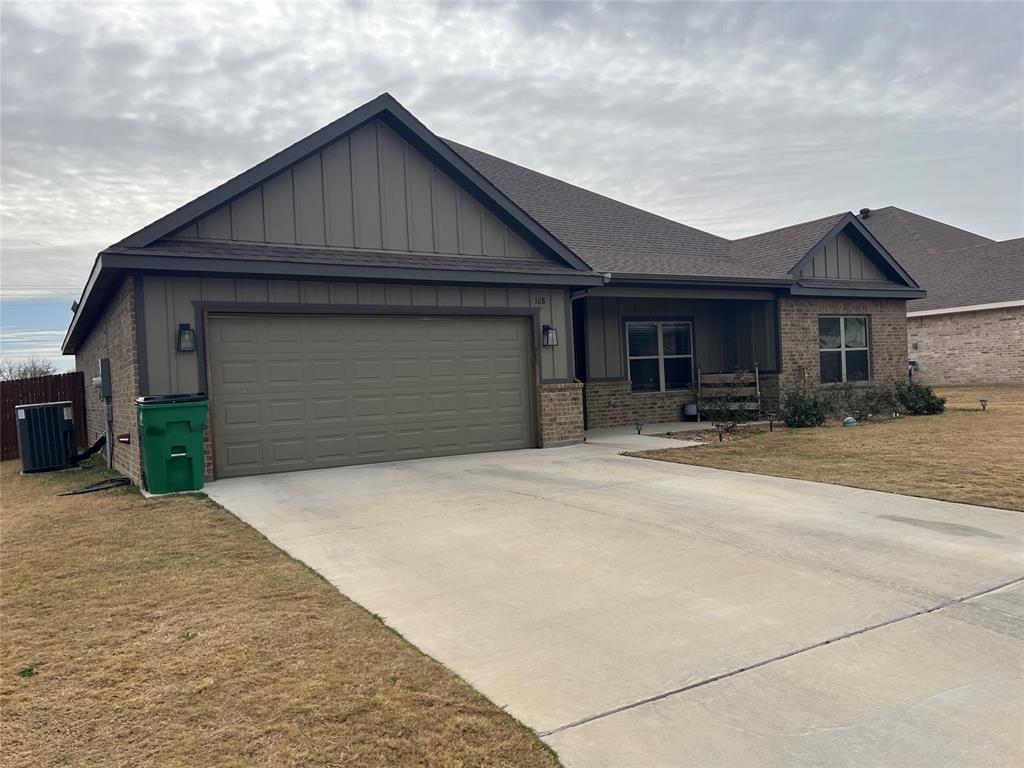 108 Wiley Stephenville, TX 76401 - Photo 2 of 25 a front view of a house with a yard and garage
