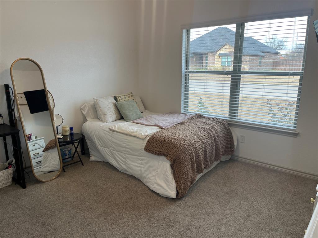 108 Wiley Stephenville, TX 76401 - Photo 7 of 25 a bedroom with a bed a table and window