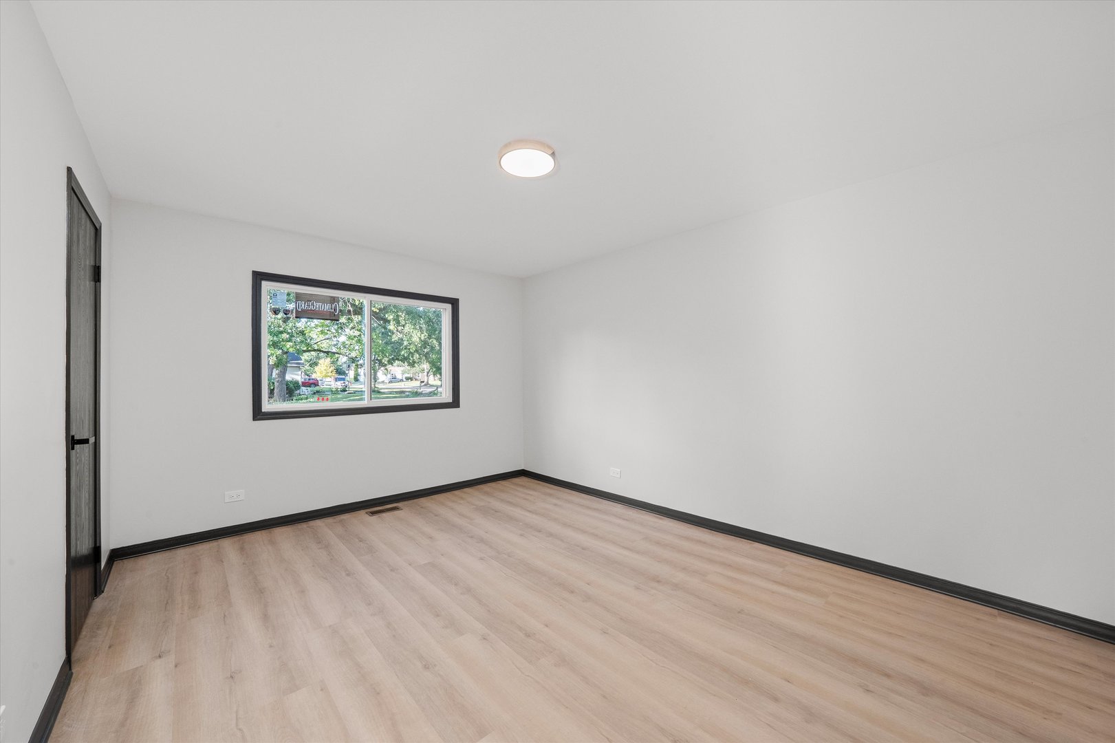 8040 Geneva Street Woodridge, IL 60517 - Photo 12 of 32 an empty room with wooden floor and windows