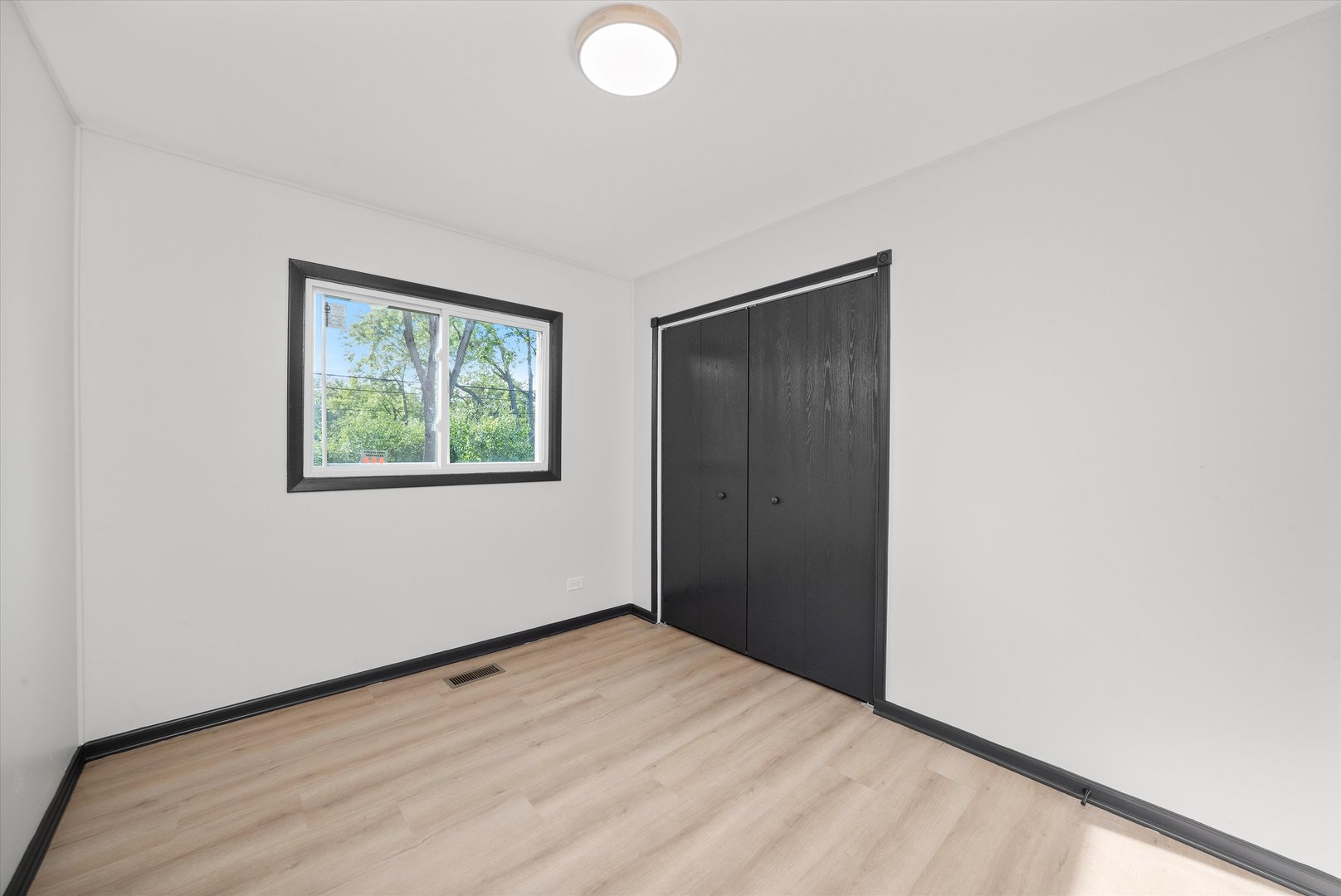 8040 Geneva Street Woodridge, IL 60517 - Photo 20 of 32 a view of an empty room with wooden floor and window