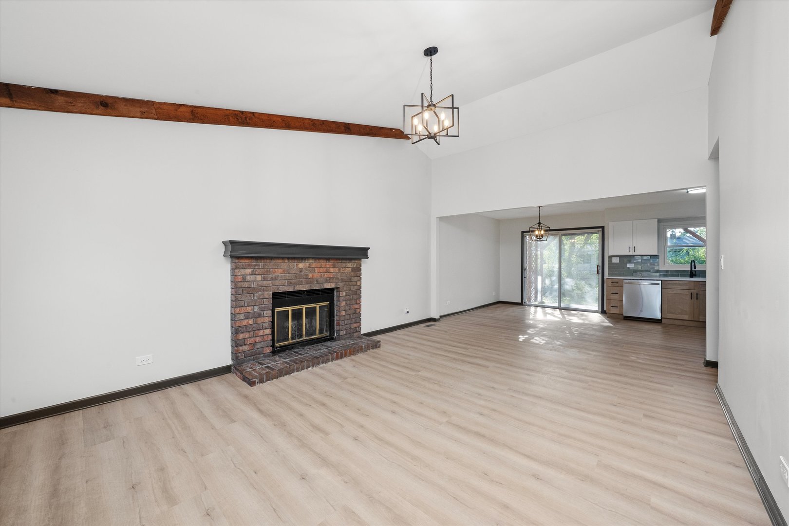 8040 Geneva Street Woodridge, IL 60517 - Photo 3 of 32 a view of a livingroom with a fireplace a chandelier and wooden floor