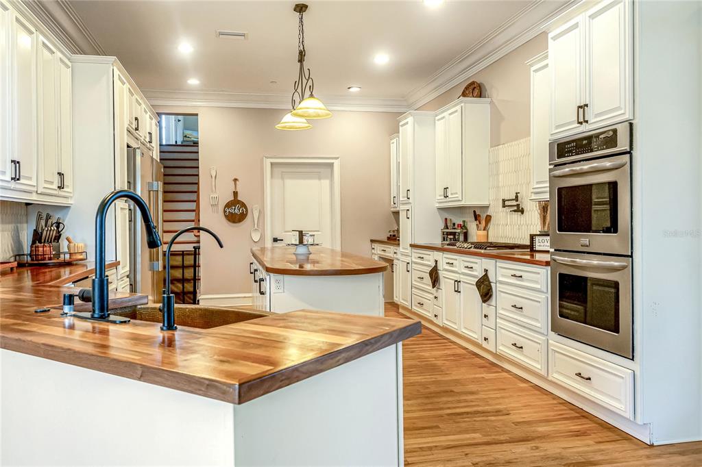 34175 Steeple Chase Way Callahan, FL 32011 - Photo 13 of 66 a kitchen with kitchen island granite countertop a stove top oven a sink a counter space and cabinets