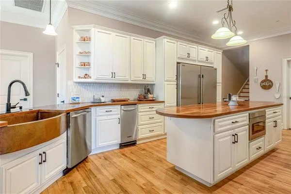 a kitchen with stainless steel appliances granite countertop a sink a refrigerator and a stove