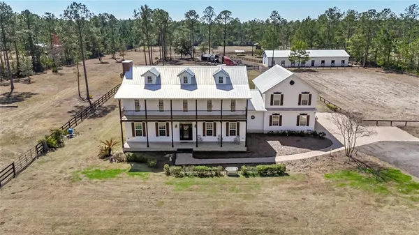 a front view of residential houses with yard and trees in the background